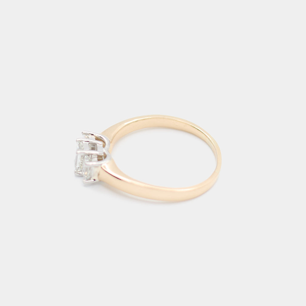 Side profile of a pre-owned 14K yellow gold engagement ring showing the polished band and emerald cut diamond settings.