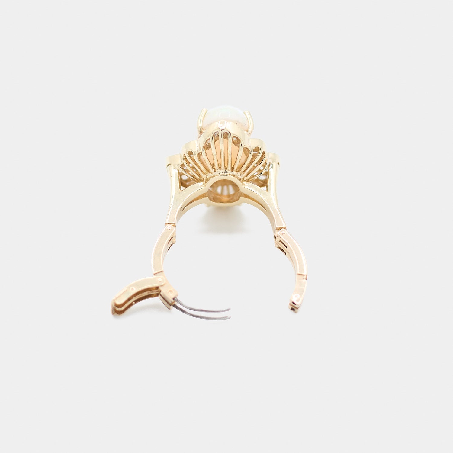 Back view of a pre-owned 14K yellow gold opal ring with the hinged adjustable band shown open, revealing the expandable sizing mechanism.