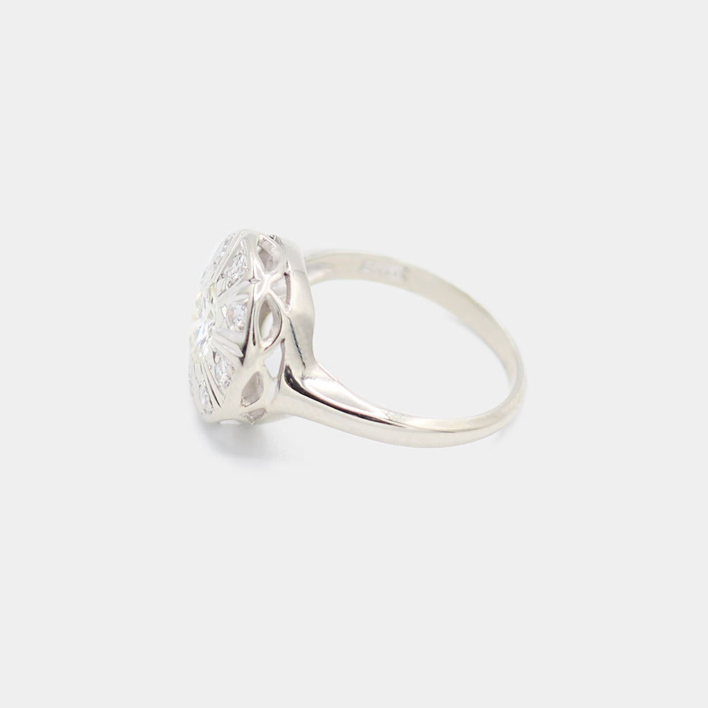 Side profile of a pre-owned 14K white gold Art Deco diamond ring showing the open filigree gallery and quatrefoil cutout detail beneath the diamond face.