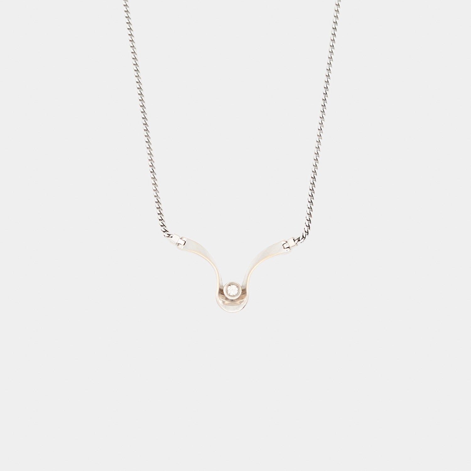 Close-up of the 14K white gold pendant featuring a center-set round cut diamond, highlighting the 3/4 inch by 1 1/8 inch design and 8.08 gram weight.