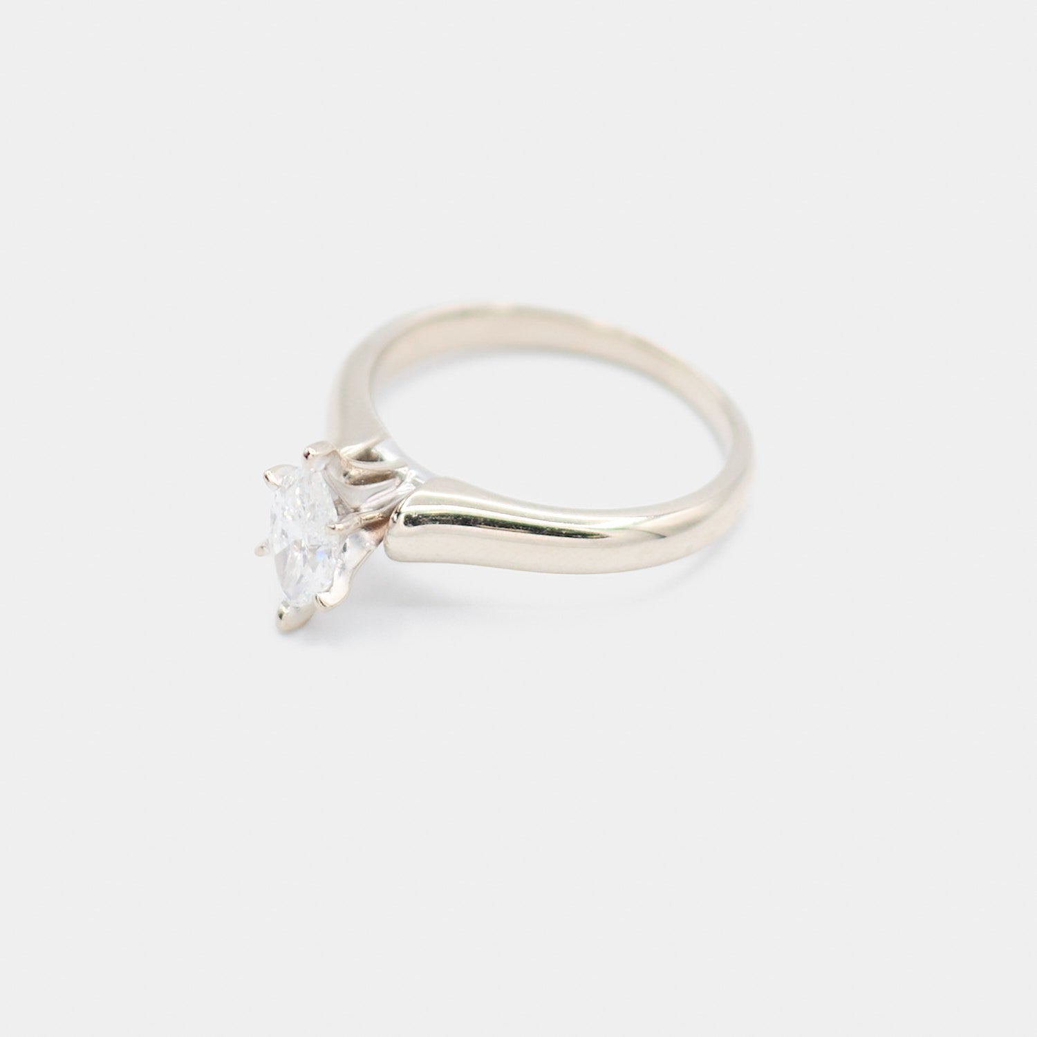 Angled 3/4 view of a pre-owned 14K white gold engagement ring showing the marquise diamond and prong setting detail.
