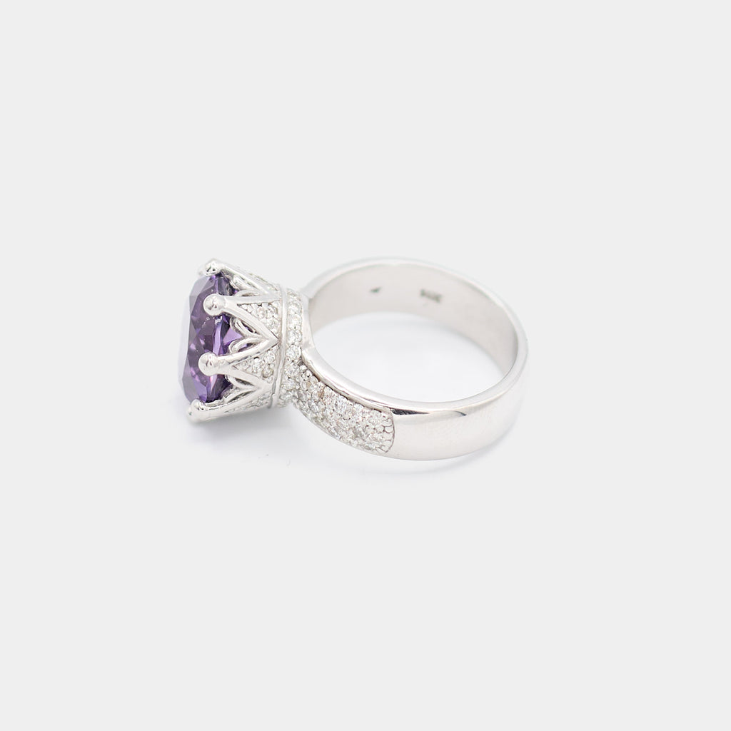 Side profile of a pre-owned 14K white gold ring showing the crown prong setting of the purple center stone and pave diamond chip detail along the band.
