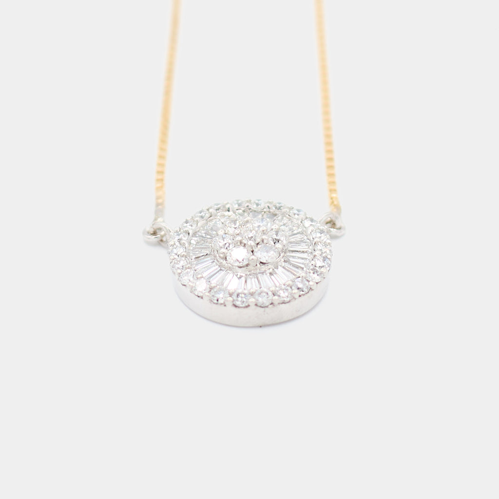 Angled front view of a pre-owned 18K white gold diamond pendant necklace, showing the depth and dimension of the round and baguette diamond halo setting.