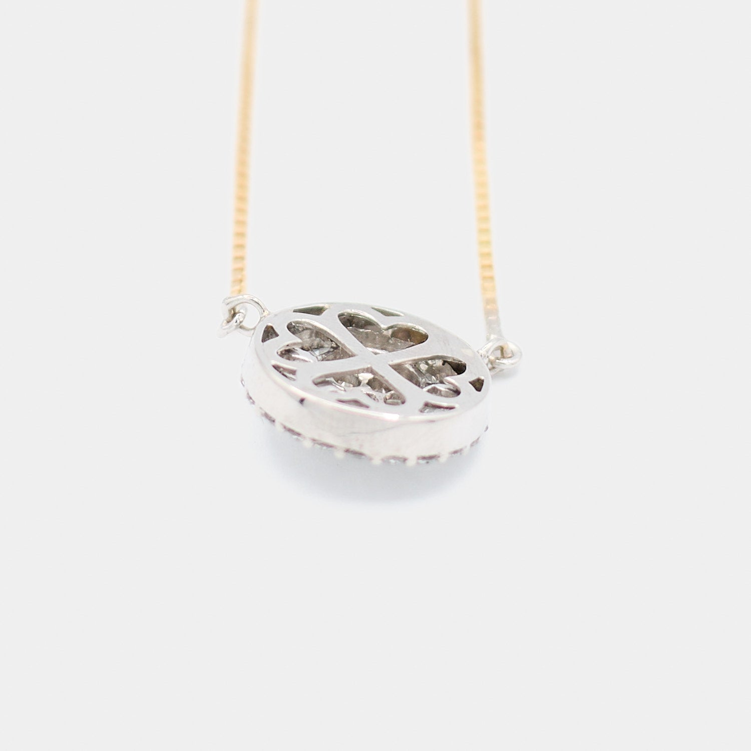 Back angled view of a pre-owned 18K white gold diamond pendant showing the open gallery with scalloped cutout design, attached to an 18K yellow gold box chain.
