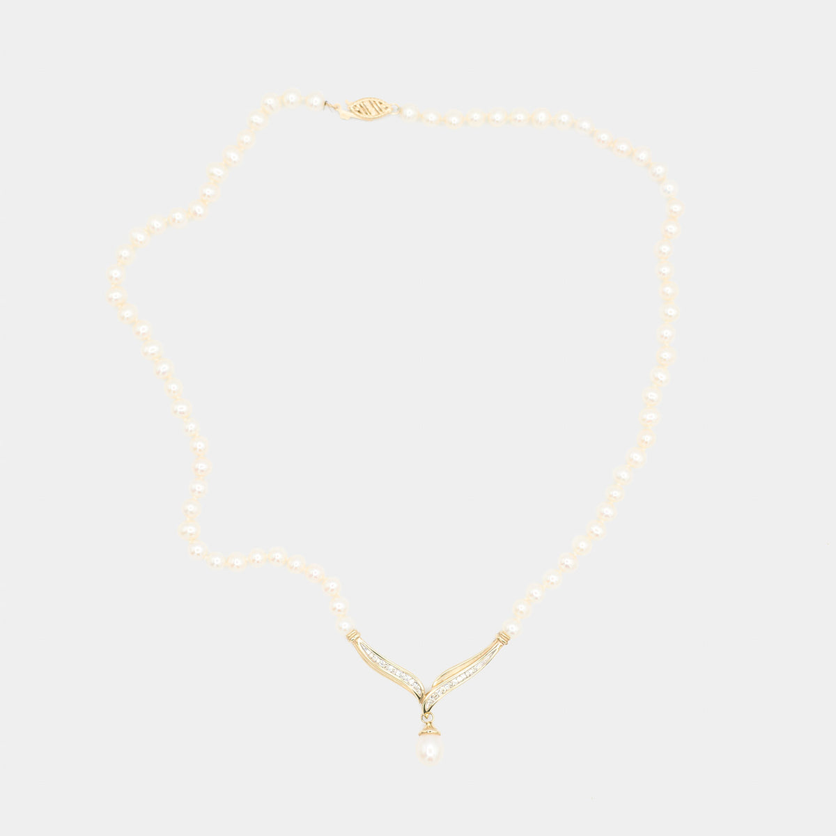 Full length front view of a pre-owned pearl necklace laid flat, showing the complete strand, diamond centerpiece, and clasp. Weighs 16.56 grams.