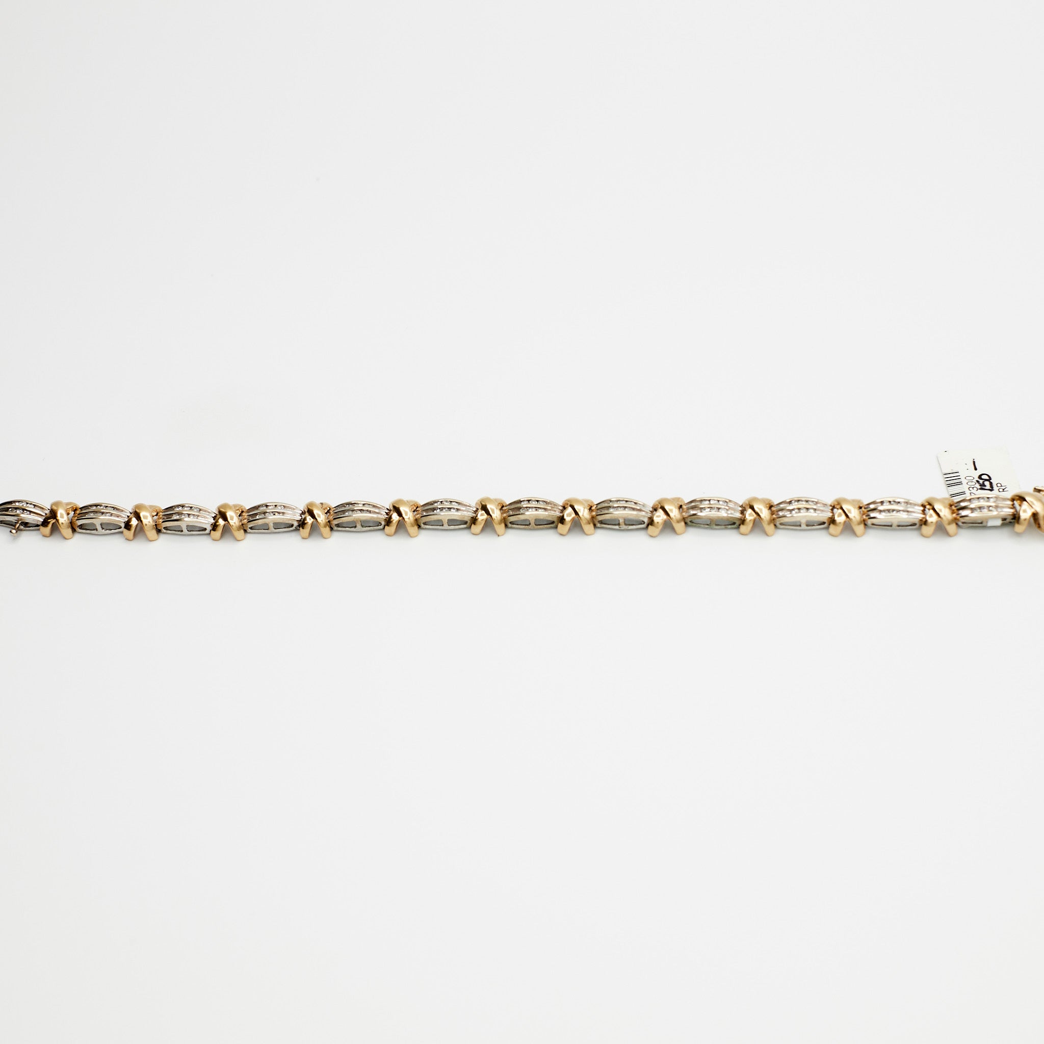 Close-up view of the 10K Dual Tone 'X' link diamond bracelet, laid flat, showcasing the interlocking gold links and 13.63 gram weight.