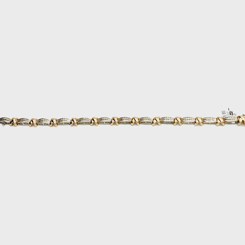 Close-up view of the 10K Dual Tone 'X' link diamond bracelet, laid flat, showcasing the interlocking gold links and 13.63 gram weight.
