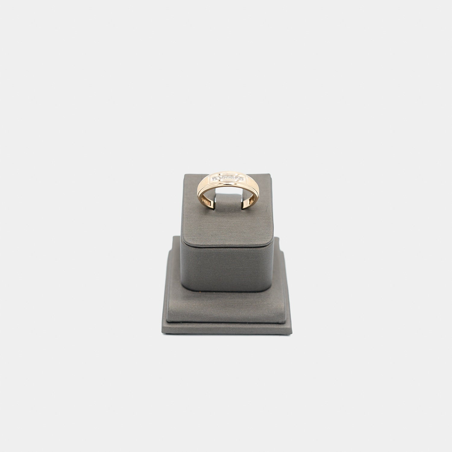 Verified pre-owned 10K yellow gold ring, size 10.25, featuring a brilliant .07 carat round cut diamond on a grey display stand.