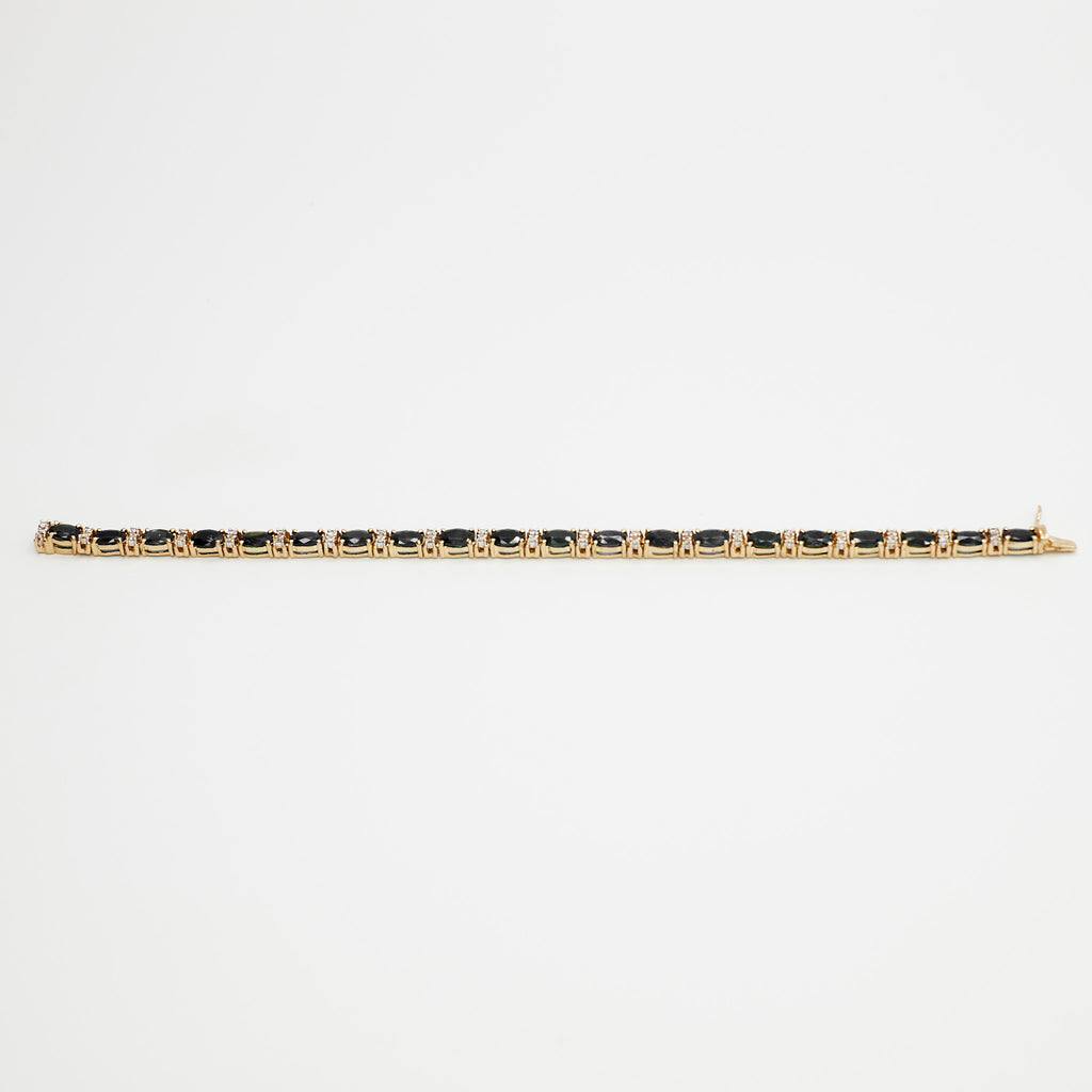Close-up view of the 14K gold multi-gemstone tennis bracelet with blue and white stones, laid flat on a white background.