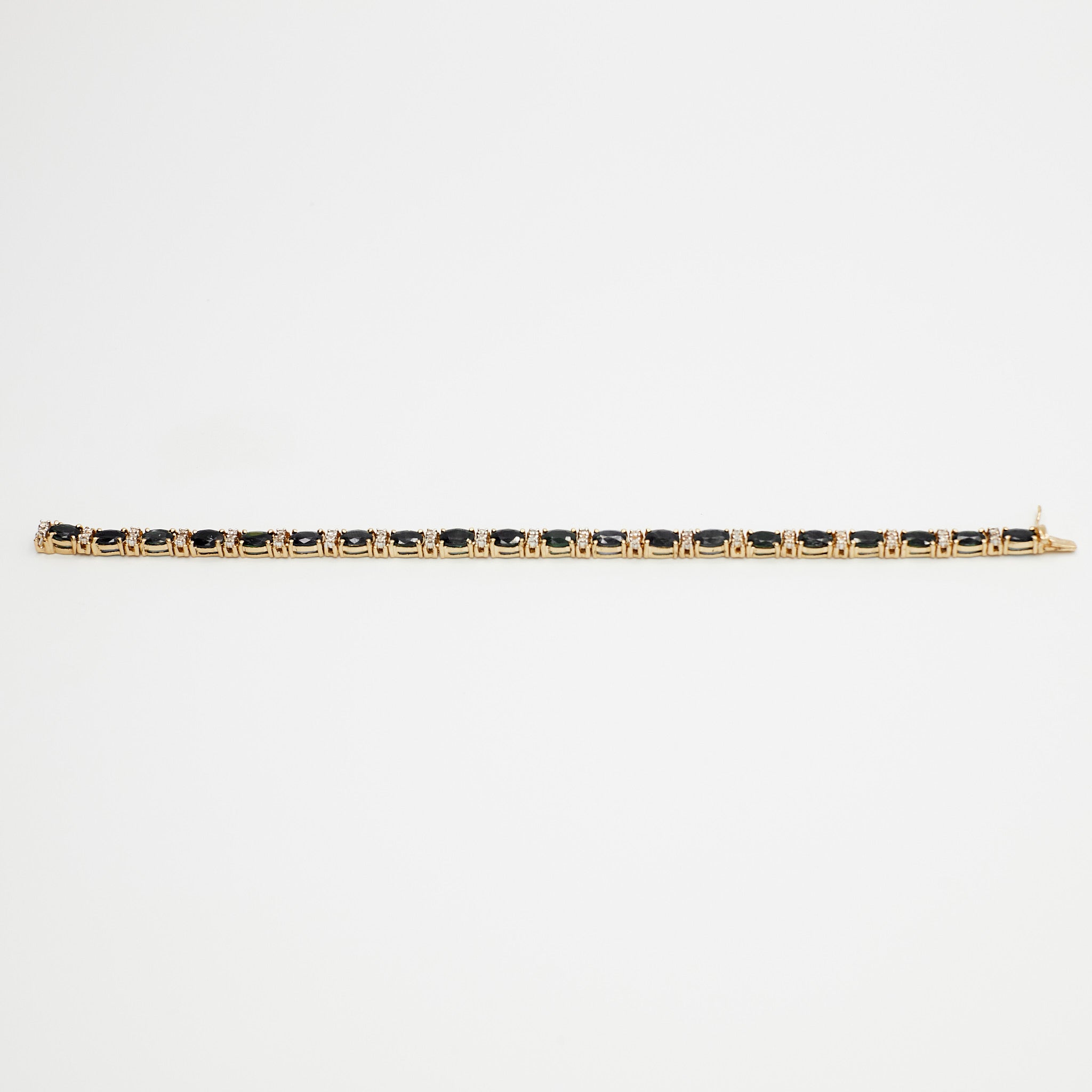 Close-up view of the 14K gold multi-gemstone tennis bracelet with blue and white stones, laid flat on a white background.