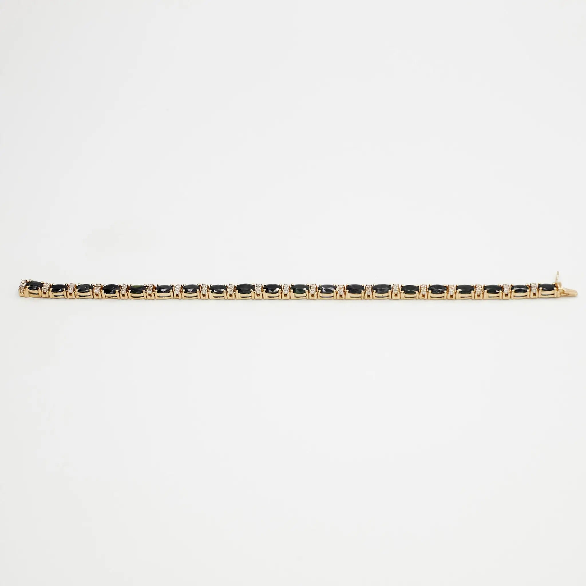 Close-up view of the 14K gold multi-gemstone tennis bracelet with blue and white stones, laid flat on a white background.