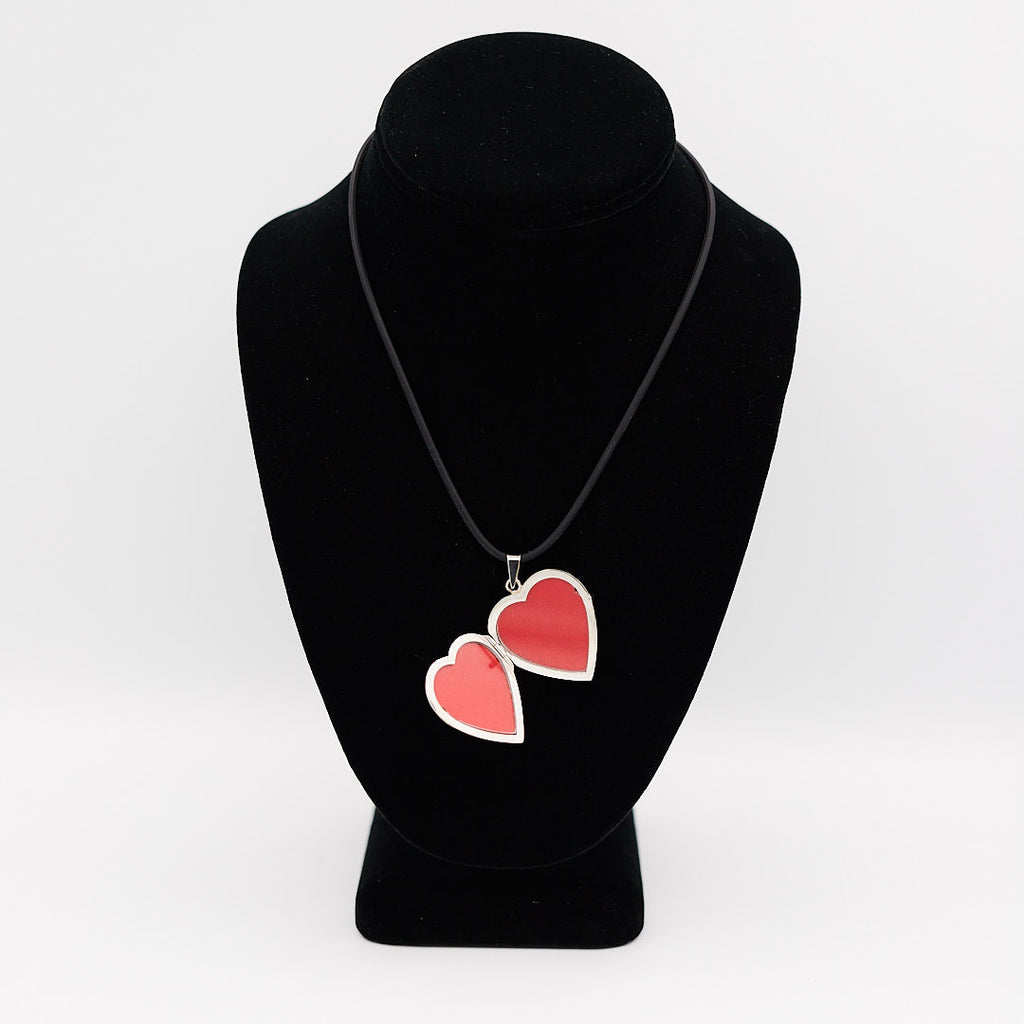 Verified 14K white gold heart photo locket, opened to show the two interior red spaces for holding cherished photographs.