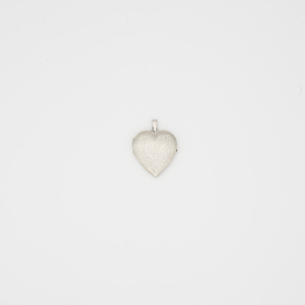 Close-up view of the 14K white gold heart photo locket, closed and laid flat, showcasing the front design and 9.89 gram weight.