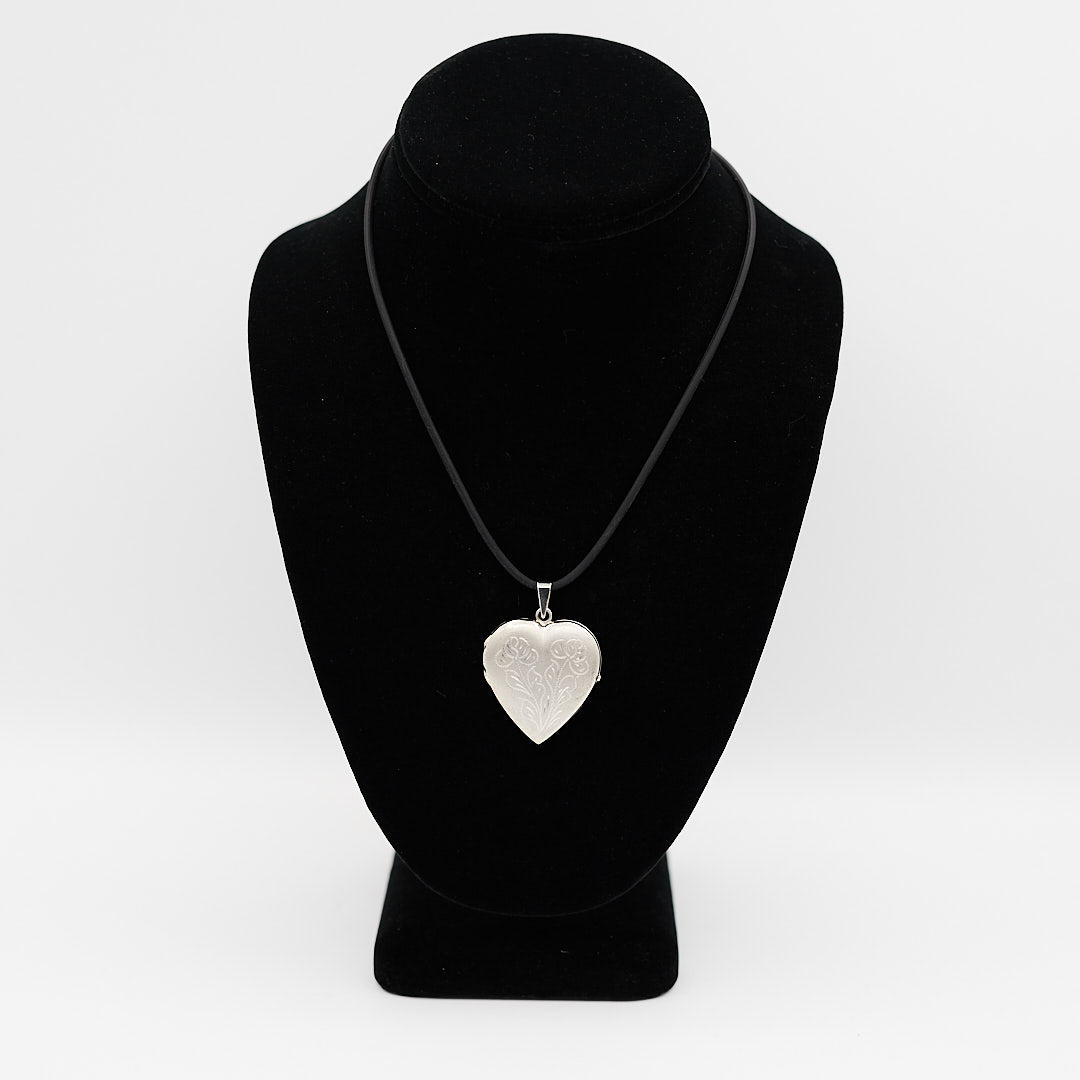 Verified pre-owned 14K white gold heart photo locket pendant, 1.625 inches long, displayed closed on a black mannequin for scale.