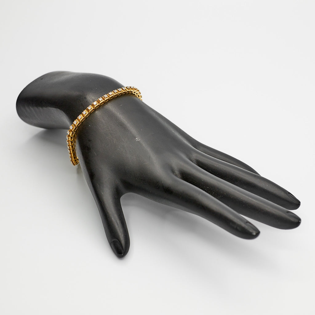 Verified 18K gold diamond tennis bracelet, 7 inches, styled on a mannequin hand to showcase the elegant drape and fit.
