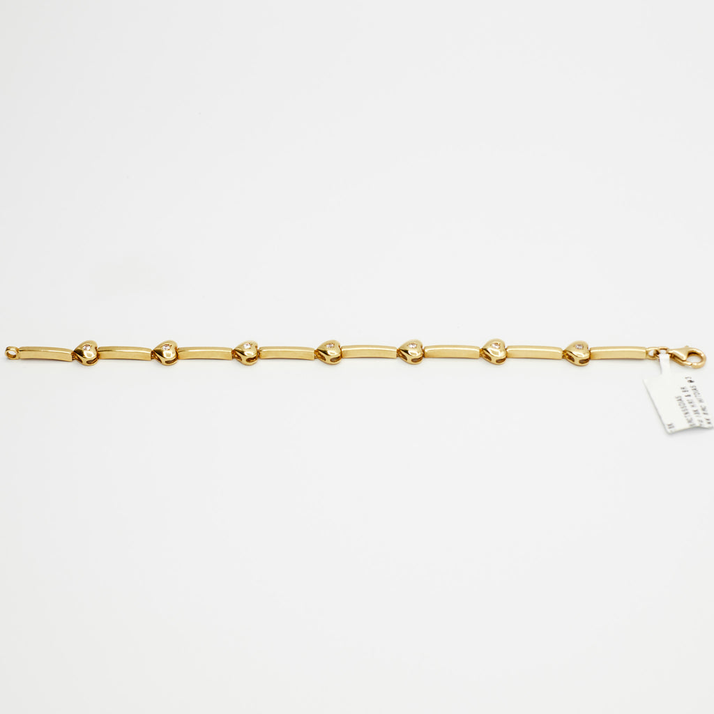 Close-up view of the 18K gold diamond heart charm bracelet, laid flat, showcasing the multiple diamond-set heart charms and 10.56 gram weight.