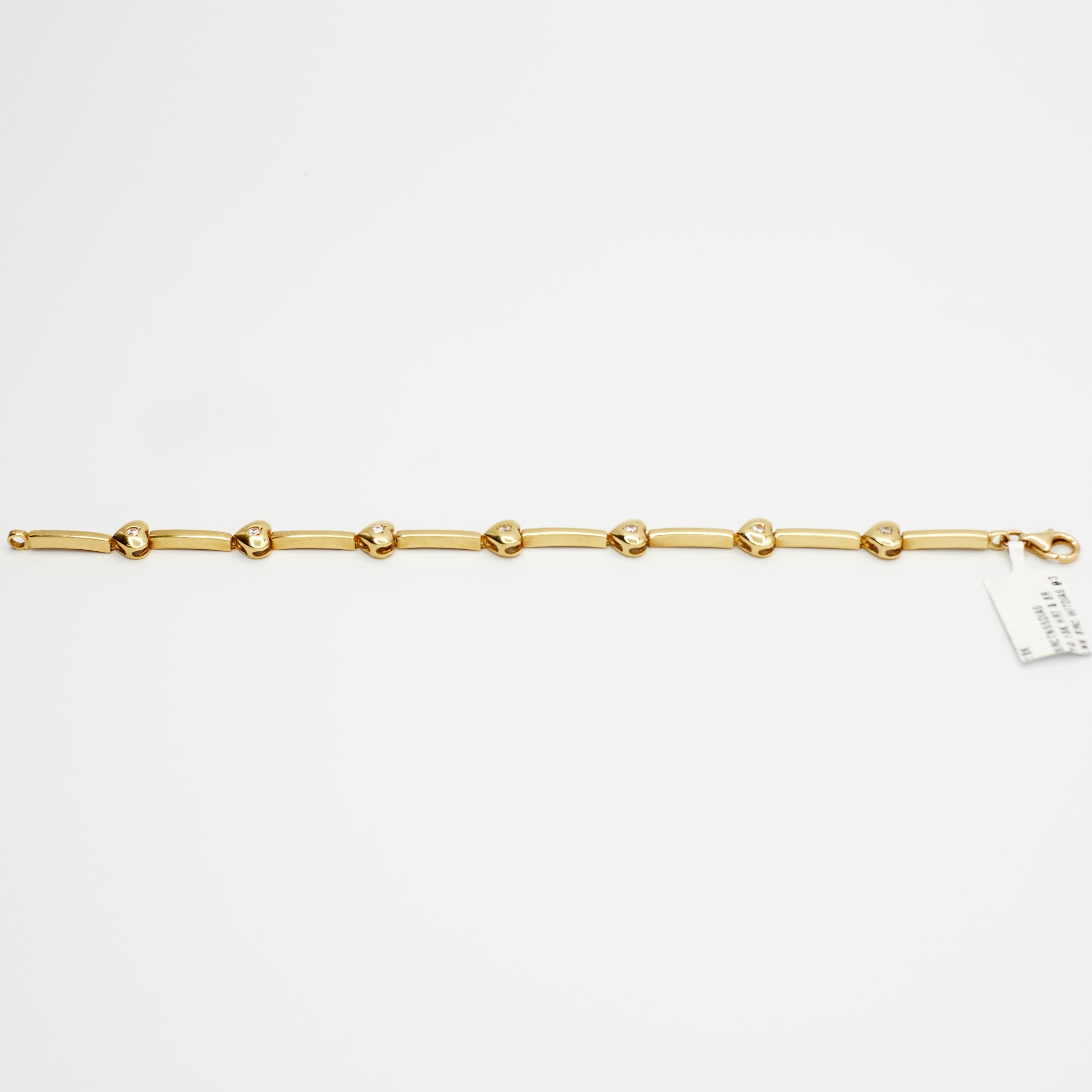 Close-up view of the 18K gold diamond heart charm bracelet, laid flat, showcasing the multiple diamond-set heart charms and 10.56 gram weight.