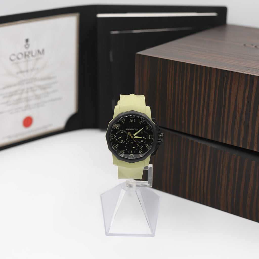 Front view of the Corum Admirals Cup Challenger 44 watch, displayed alongside its original presentation box and instruction manual/paperwork.