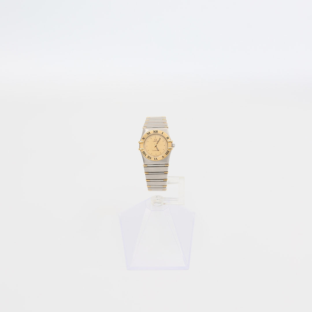 Verified pre-owned Omega Constellation 22mm watch, showcasing 18K gold bezel, 18K gold dial, and stainless steel bracelet