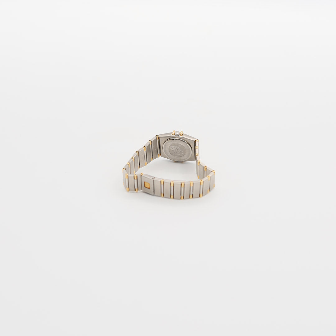 Underside view of the Omega Constellation 18K gold and steel watch, highlighting 18K end links and the 24.6 gram total weight.