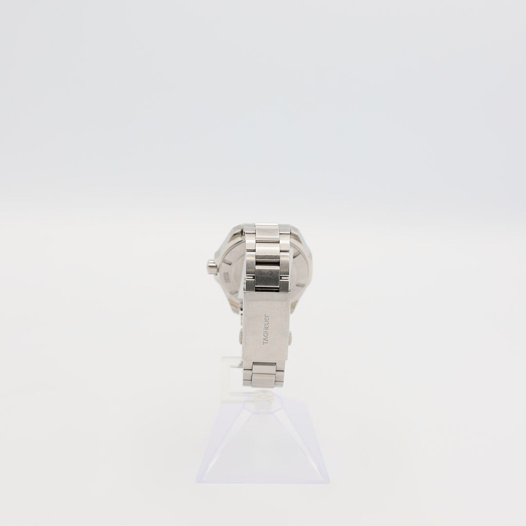 Back view of the TAG Heuer Aquaracer 43mm stainless steel watch standing up, highlighting the engraved diver case back and the 126.84 gram weight.